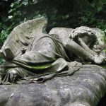 Angel sleeping on top of a grave in the western section of Highgate Cemetery