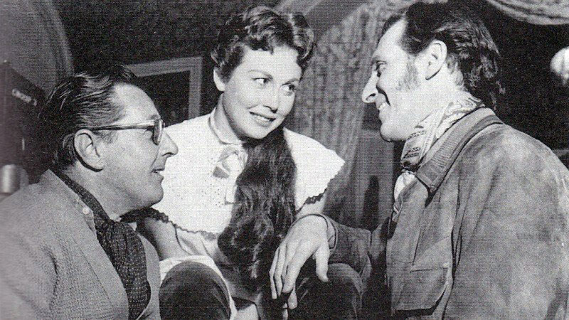 Director Terence Fisher chats with actors Hazel Court and Peter Cushing during making of The Curse of Frankenstein