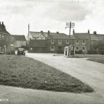 Historical image showing The Green at Atwick, the stone cross on the left of the image is said to be haunted by a strange white lady. 
