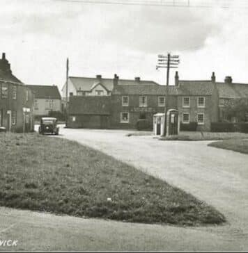 Historical image showing The Green at Atwick, the stone cross on the left of the image is said to be haunted by a strange white lady. 