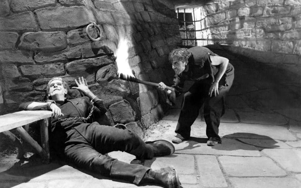 Fitz (Dwight Frye) torments the Monster (Boris Karloff) in James Whale's Frankenstein (1931)