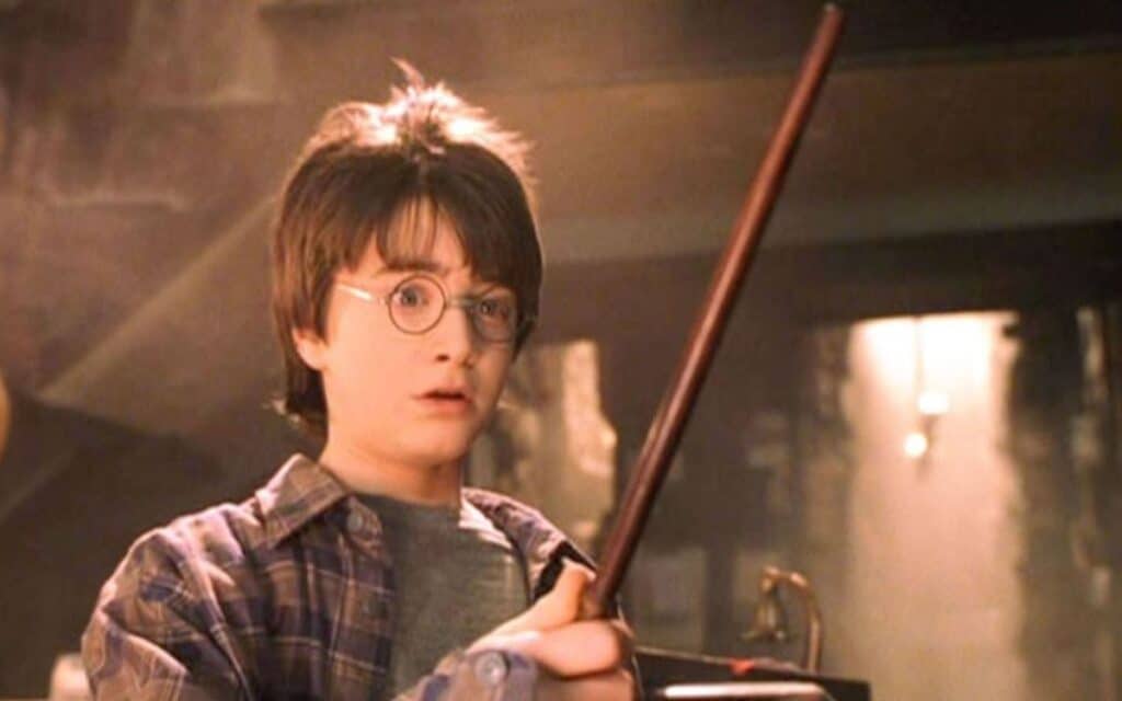 Harry Potter (Daniel Radcliffe) trying out a magic wand in Harry Potter and the Sorcerer's Stone, the first in the Harry Potter films.