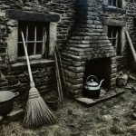 a broom and kettle outside of a stone building
