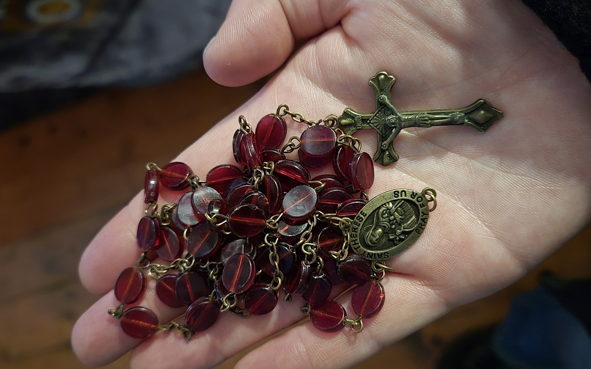 Carrying the torch: Two days with Chris McKinnell in Donegal 3 Lorraine Warren's red rosary beads and crucifix resting in a person's hand.