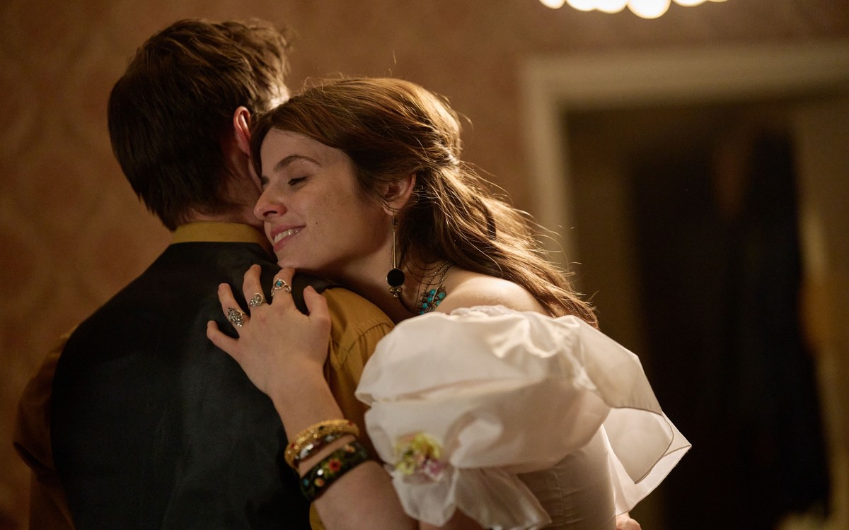 BBC confirms The Witch Farm release date 6 Gabrielle Creevy as Liz, wearing a white dress, embraces a man in The Witch Farm.